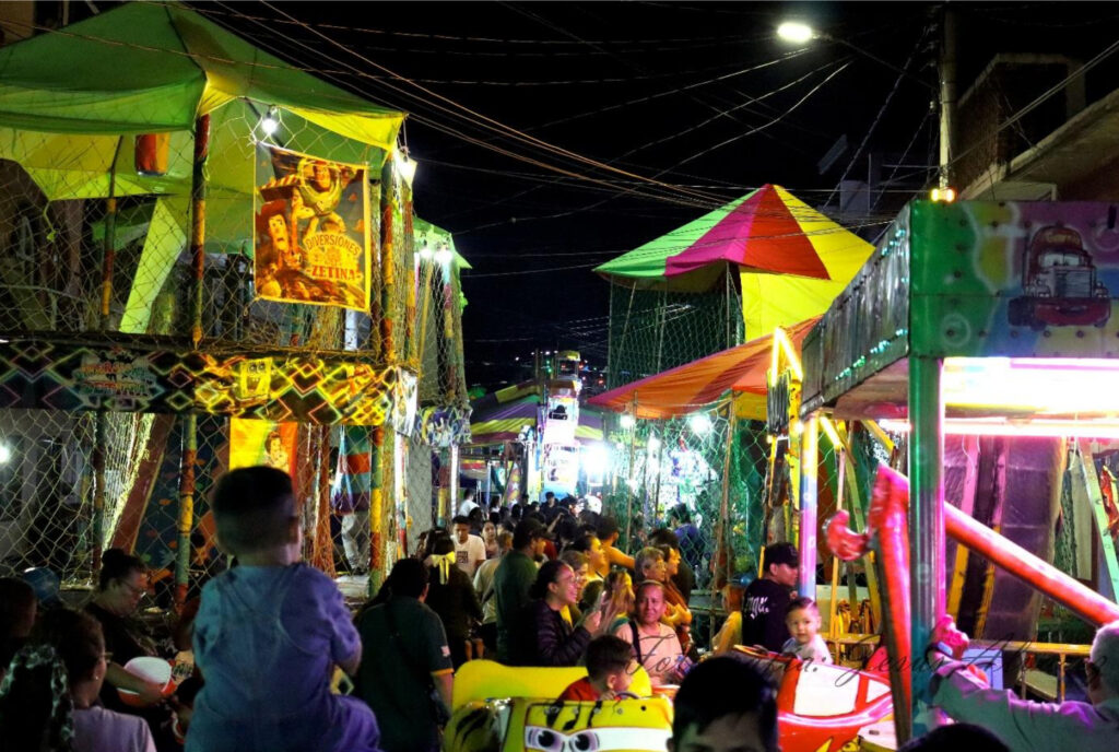 Calle Eucalipto abarrotada de personas disfrutando los juegos mecánicos [Fotografía del 
autor]